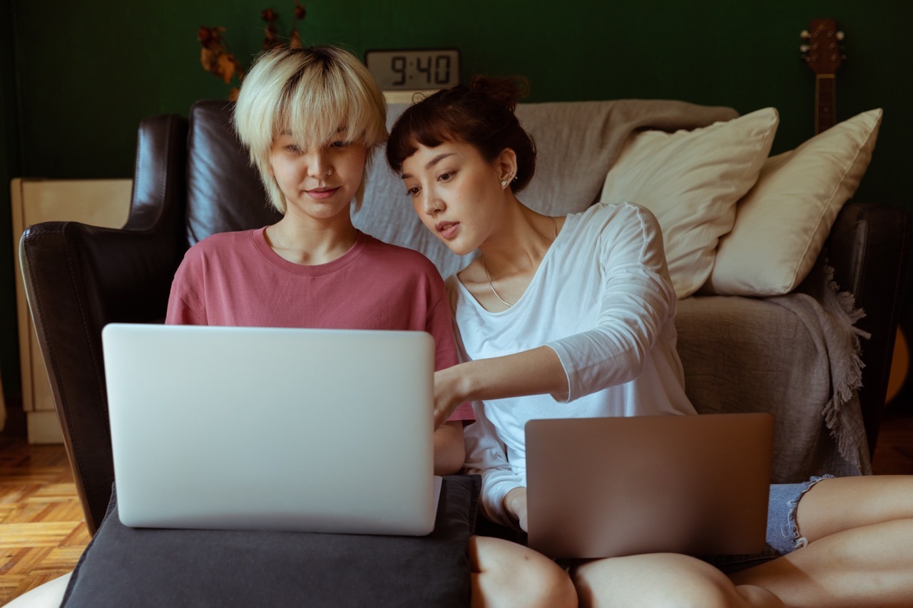 two women discussing while looking at a laptop